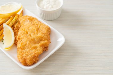balık ve patates kızartması - kızarmış balık fileto patates cipsi ve limonlu beyaz tabak