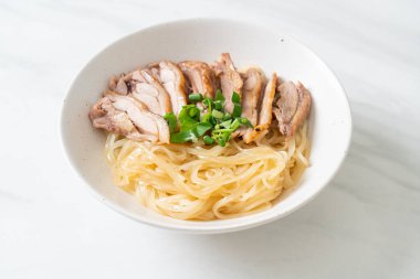 Beyaz kasede pişmiş ördekle kurutulmuş şehriye. Asya usulü.