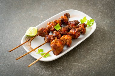 Izgara tavuk şişi. Tabakta baharat ve şifalı otlar var.