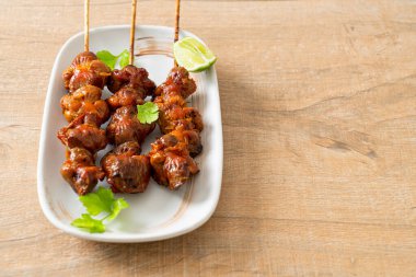 Izgara tavuk şişi. Tabakta baharat ve şifalı otlar var.