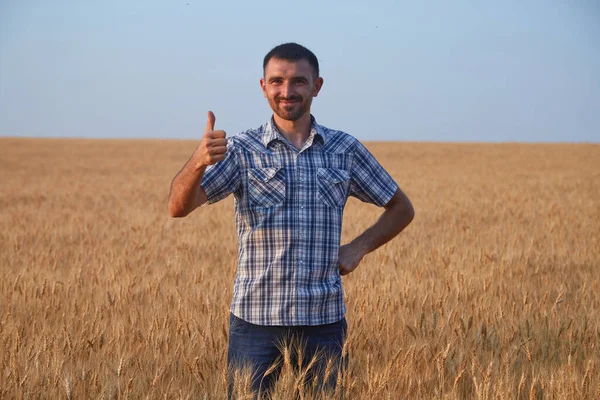 farmer in the field holds a thumbs up.