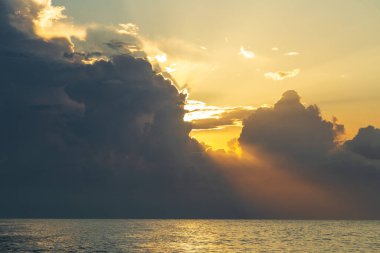 Altın saat, güneş ışınları su yüzeyinin üstündeki bulutların arasından geçer..