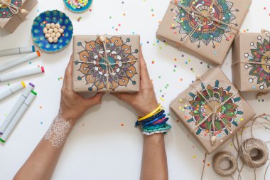 Kraft kağıt sarılmış hediyeler. Kutulara mandala desen boyalı.