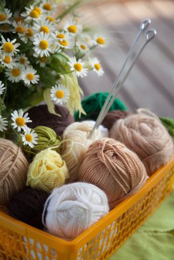 Topları ve skeins masada bir sepet içinde yalan. Renkli iplik için 