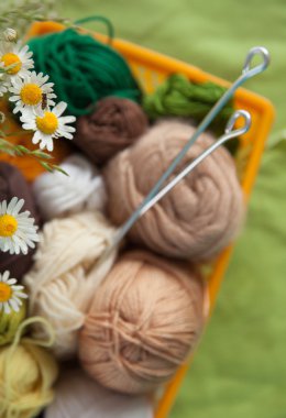 Topları ve skeins masada bir sepet içinde yalan. Renkli iplik için 