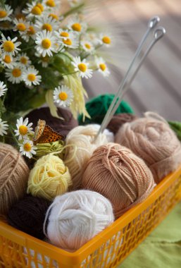 Topları ve skeins masada bir sepet içinde yalan. Renkli iplik için 