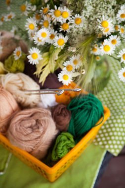 Topları ve skeins masada bir sepet içinde yalan. Renkli iplik için 
