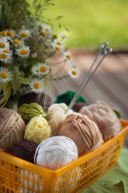 Topları ve skeins masada bir sepet içinde yalan. Renkli iplik için 