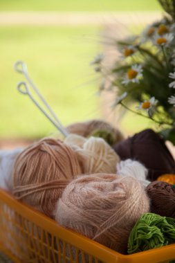 Topları ve skeins masada bir sepet içinde yalan. Renkli iplik için 