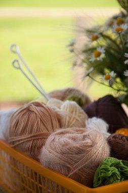 Topları ve skeins masada bir sepet içinde yalan. Renkli iplik için 
