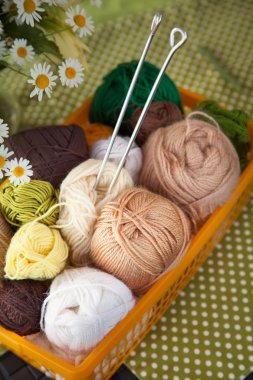 Topları ve skeins masada bir sepet içinde yalan. Renkli iplik için 