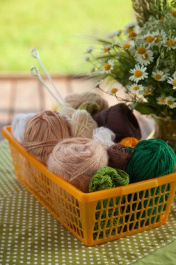 Topları ve skeins masada bir sepet içinde yalan. Renkli iplik için 