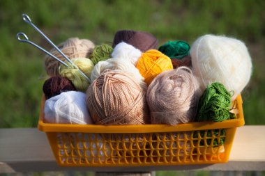 Masanın üzerinde bir sepet içinde toplar ve skeins yalan.