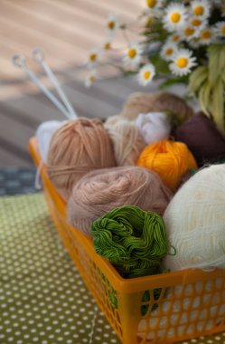 Masanın üzerinde bir sepet içinde toplar ve skeins yalan.