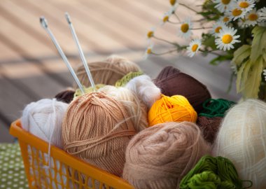 Masanın üzerinde bir sepet içinde toplar ve skeins yalan.