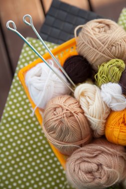 Masanın üzerinde bir sepet içinde toplar ve skeins yalan.