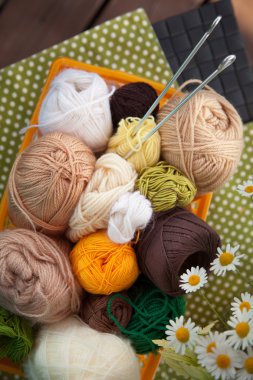 Masanın üzerinde bir sepet içinde toplar ve skeins yalan.