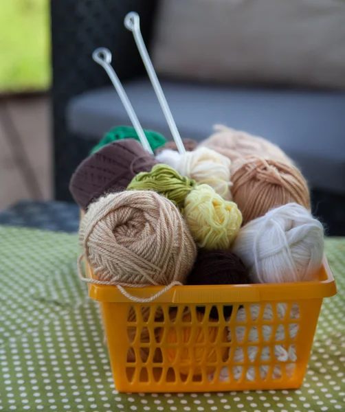 Topları ve skeins masada bir sepet içinde yalan. Renkli iplik için 