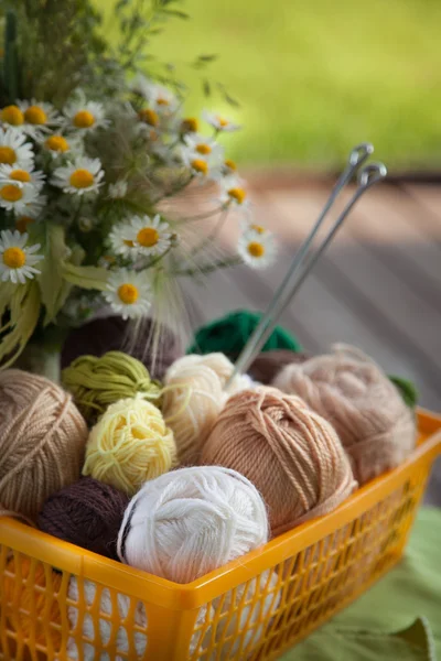 Topları ve skeins masada bir sepet içinde yalan. Renkli iplik için 