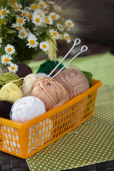 Balls and skeins lie in a basket on the table. Colored yarn for — Stock Photo, Image