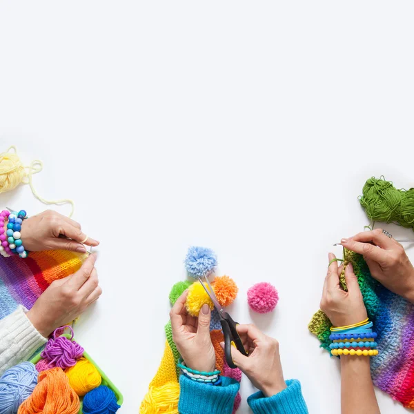 De vrouwen breien en haken van gekleurde stof. Van bovenaf bekijken. — Stockfoto