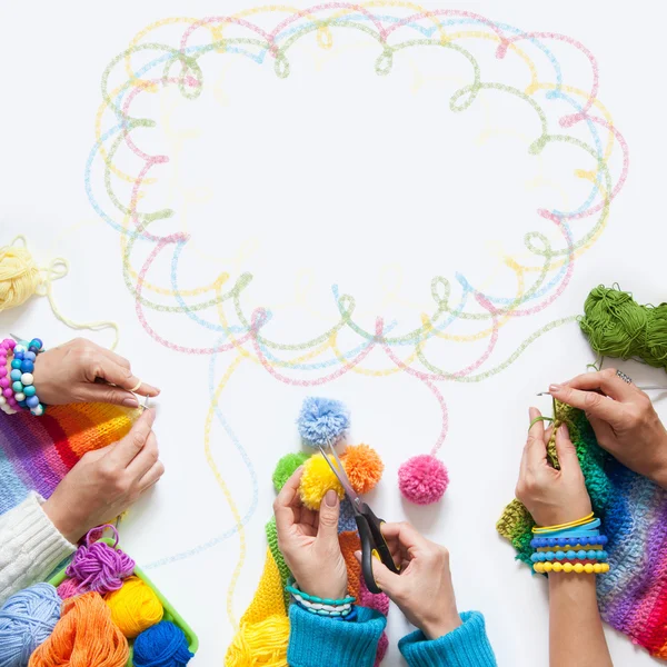 De vrouwen breien en haken van gekleurde stof. Van bovenaf bekijken. — Stockfoto