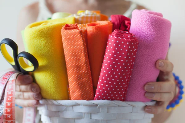 Женщина держит яркие цветные ткани для шитья и ножниц . — стоковое фото