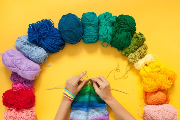 Palle di filato colorato. Campione di maglia. Le mani delle donne sono lavorate a maglia . — Foto Stock