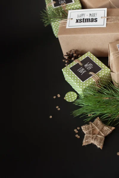 Gifts wrapped in brown craft paper on a black background. The br — Stock Photo, Image