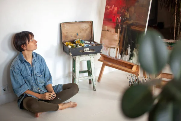Seniman Wanita Dengan Kuas Cat Duduk Melihat Lukisan Minyak Dicat — Stok Foto