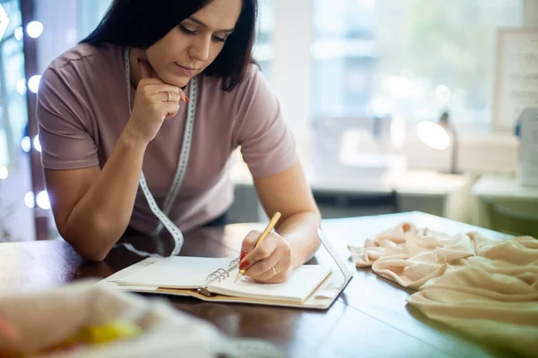 Bella Giovane Donna Designer Sta Prendendo Appunti Misure Abbigliamento Notebook — Foto Stock