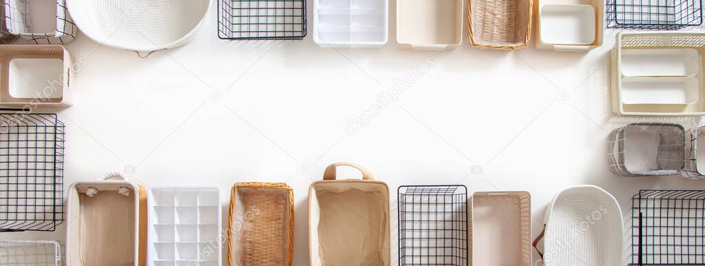 Top view of empty closet organization boxes and steel wire baskets in different shape placed on white marble table with copy space. Marie Kondos boxes for tidying clothes and drawer storage. 