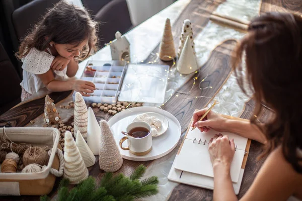 여성이 마시고 2021 계획이나 목표를 세우는 크리스마스 트리를 단추를 요정등을 — 스톡 사진