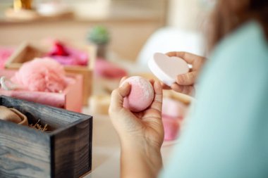 Kadın, kadın için pembe renkli kalp şeklinde hediye kutuları hazırlıyor organik doğal vücut bakımı kozmetikleri ve kadınlar için şekerli şekerlemeler, anneler günü ya da sevgililer günü. Nedime hediye kutusu fikri.
