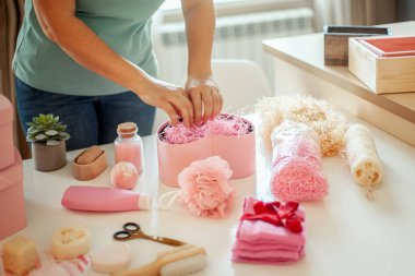 Nedimeler, gelinler ve doğum günleri, yıldönümleri, sevgililer günü, anneler günü, noel için hediye kutuları ve vücut ürünleri taşıyan pembe renkli bir kalp taşıyan kadın elleri..