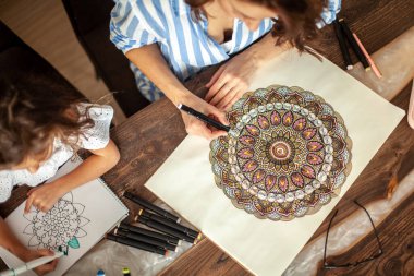 Anne ve kızı mutfaktaki evlerinde Zen boyası yapıyorlar. Meditasyon, karalama çizimi ve hobiler için kavram.