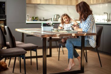 Anne ve kızı mutfaktaki evlerinde Zen boyası yapıyorlar. Meditasyon, karalama çizimi ve hobiler için kavram.