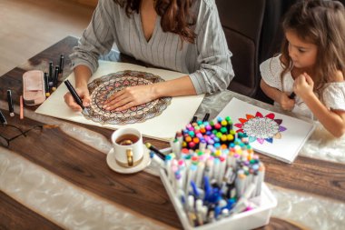 Anne ve kızı mutfaktaki evlerinde Zen boyası yapıyorlar. Meditasyon, karalama çizimi ve hobiler için kavram.