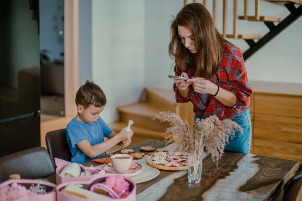 소년은 어머니에게 선물을 준비하고 쿠키를 분홍색 아이싱을 모양으로 — 스톡 사진
