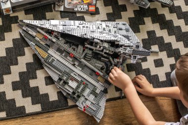 Khabarovsk, Rusya, Janyary 10, 2021. Bir çocuk, Star Wars filminden bir uzay gemisini oynuyor ve inceliyor. Yakınlarda Milenyum Şahini yatıyor..