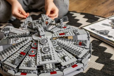 Khabarovsk, Rusya, Janyary 10, 2021. Bir çocuk, Star Wars filminden bir uzay gemisini oynuyor ve inceliyor. Yakınlarda İmparatorluk kruvazörü var.