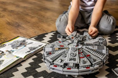 Khabarovsk, Rusya, Janyary 10, 2021. Bir çocuk, Star Wars filminden bir uzay gemisini oynuyor ve inceliyor. Yakınlarda İmparatorluk kruvazörü var.