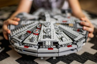 Khabarovsk, Rusya, Janyary 10, 2021. Çocuk, Star Wars filmindeki uzay gemisini gösteriyor. Büyük Lego Seti. Çocuk Lego Millennium Falcon 'un uzay gemisini gösteriyor. Star Wars filminden..