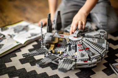 Khabarovsk, Rusya, Janyary 10, 2021. Bir çocuk, Star Wars filminden bir uzay gemisini oynuyor ve inceliyor. Yakınlarda İmparatorluk kruvazörü var.