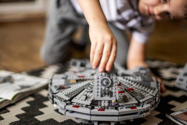 Khabarovsk, Rusya, Janyary 10, 2021. Bir çocuk, Star Wars filminden bir uzay gemisini oynuyor ve inceliyor. Yakınlarda İmparatorluk kruvazörü var.