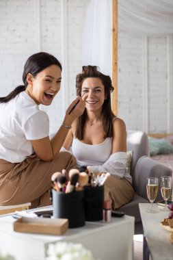 Kadın vizojist, kadın müşteriye makyaj malzemesi uyguluyor evde hazırlanıyor. Makyaj sanatçısı boya işinde çalışıyor. İki bayan arkadaş birlikte zaman geçiriyorlar. Gardırop Roo 'da hazırlık yapıyorlar.