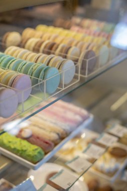 Şekerci dükkanındaki cam vitrinde bir sürü renkli makarna ekini var. Vitrindeki kremalı tatlı pastel tatlılar iştah açıcı. Pasta ya da kek kurabiyesi çeşitleri.