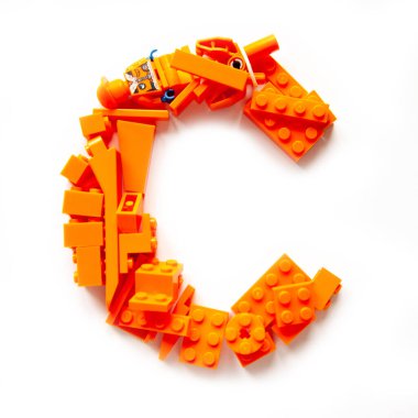 Khabarovsk, Rusya, 17 Kasım 2020. Beyaz arkaplanda lego tuğlaları ve minyatür figürlerle yapılmış renkli bir C harfi. Çok renkli lego oyuncak setiyle el yapımı.. 