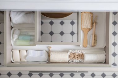 Marie Kondo 'nun modern açık raf kutusundaki banyo konforları metodu. Bembeyaz çekmecede ya da dolabın üst görünümünde tuvalet malzemeleri. Çağdaş temizlik ya da depolama alanı