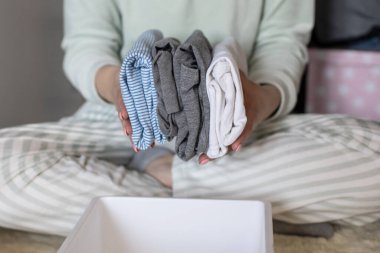 İç çamaşırı ve tişört depolarını düzenleyen kadın eller Marie Kondo 'nun yöntemini kullanır. Kusursuz ev hanımı gardırop organizatörlerine kıyafet yerleştiriyor. Giyim düzenleme çözümleri düzgünce ayarlanıyor